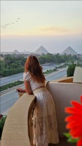 开罗Pyramids sunrise inn的坐在船舱的女装,望着一条河