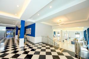 黎府Marble Arch De Loei Hotel的大堂设有格子地板和蓝色的墙壁