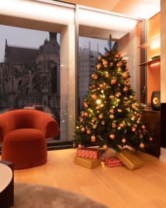 兰斯Les 7 Anges - Cathédrale de Reims的椅子房间里一棵圣诞树