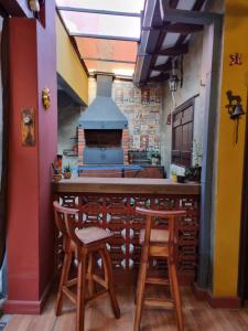 亚松森Mi lugar Vintage Hostal - calor de hogar!的厨房设有带凳子和炉灶的酒吧。