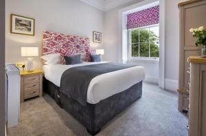 普利布里奇Waterfoot Park的一间卧室设有一张大床和一个窗户。