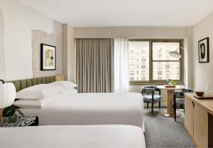纽约Kimpton Hotel Theta, an IHG Hotel的酒店客房配有两张床和一张书桌