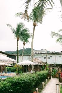 马利西亚斯Lua Chales的一座棕榈树度假村,位于一座建筑前