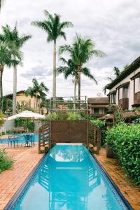 马利西亚斯Lua Chales的一个带蓝色椅子的游泳池,棕榈树