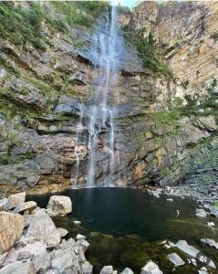戈亚斯州上帕莱索Villa de Assis Suítes的山前水面上的瀑布