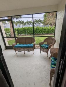 迈尔斯堡NEW condo! Just 15 min to Ft Myers and Sanibel beach! Great Location!!的门廊设有2把椅子和1张沙发