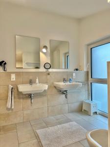 奥尔登堡Ferienhaus Oldenburg的浴室设有2个水槽和镜子
