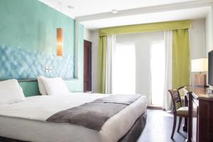 圣地亚哥蓝树创始人酒店的一间卧室配有一张床、一张书桌和一个窗户。