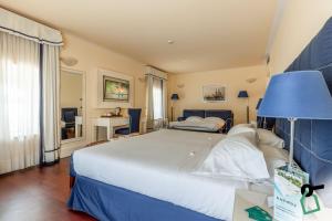 利沃诺HOTIDAY Hotel Livorno的卧室配有一张白色大床和蓝灯