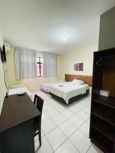 福塔莱萨Netuno Beach Hotel的一间卧室配有一张床、一张桌子和一张书桌