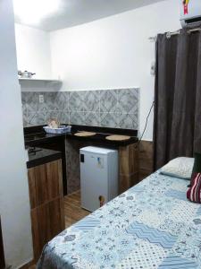 凯鲁Suíte, Bem localizado em Morro de São Paulo Ba的客房设有一张床、一张书桌和一台冰箱