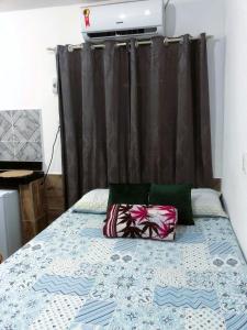 凯鲁Suíte, Bem localizado em Morro de São Paulo Ba的卧室内的一张带两个枕头的床