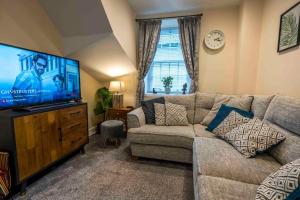 肯德尔Cosy Cottage in Central Kendal with Parking!的带沙发和平面电视的客厅