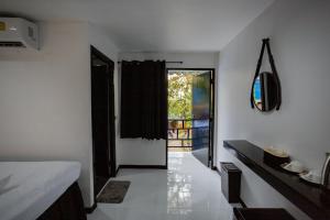 皮皮岛The Bright House, Koh Phi Phi的一间设有卧室的客房,卧室设有通往阳台的门