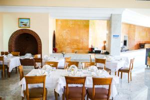 马赫迪耶Mahdia Palace Thalasso的用餐室配有白色的桌子和木椅