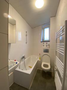 曼海姆Annie´s Appartements的白色的浴室设有浴缸和卫生间。