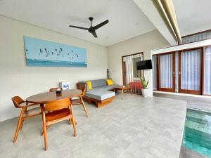 登巴萨Livin Sanur Villa的客厅配有桌子和沙发