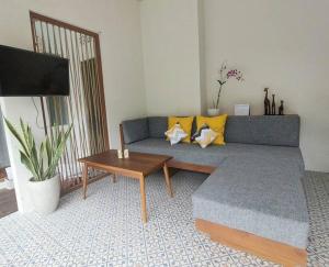 登巴萨Livin Sanur Villa的客厅配有蓝色的沙发和桌子