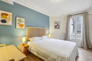 巴黎Hôtel Juliette的卧室配有一张白色的大床和一张桌子
