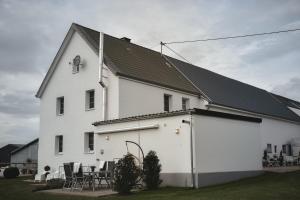达勒姆Ferienhaus Landliebe-Wohlfühlzeit in der Eifel-的前面设有桌椅的白色房子