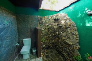 锡吉里亚Sigiri Close-up View Guest的浴室设有石墙和蓝色卫生间。