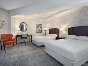 沃尔斯雷Delta Hotels by Marriott Worsley Park Country Club的酒店客房配有两张床和一张书桌