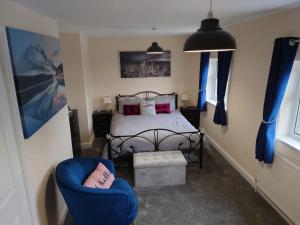 特伦特河畔斯托克Family friendly home near Alton Towers的一间卧室配有一张床和一张蓝色椅子