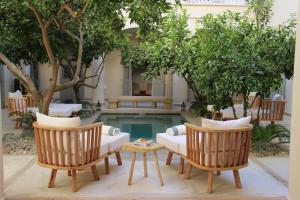 马拉喀什安贝瑞扎哈里摩洛哥传统庭院住宅的一个带两把椅子和一张沙发的庭院和一个游泳池