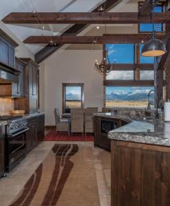 蒂托尼亚Postcard Views, Teton Valley Id的大型厨房设有木制橱柜和大窗户
