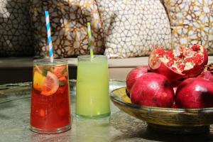 马拉喀什安贝瑞扎哈里摩洛哥传统庭院住宅的两杯饮料放在一碗水果旁边的桌子上
