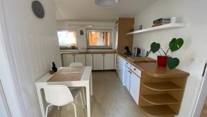 克拉根福Wohnung am Spitalberg的厨房配有白色橱柜和桌椅