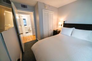 五月岬郡矶鹞海滩俱乐部酒店的一间带白色大床的卧室和一间浴室