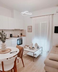 卡尔季察Iliana's apartment的白色的客厅配有桌子和沙发