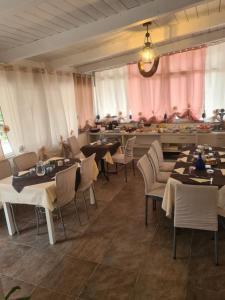 ChiaromonteAgriturismo Cara Terra Lucana的一间带桌椅和粉红色窗帘的餐厅
