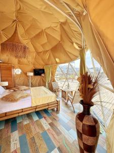 艾福雷诺德精品城堡公寓式酒店的一个带花瓶的帐篷内一间卧室,配有一张床