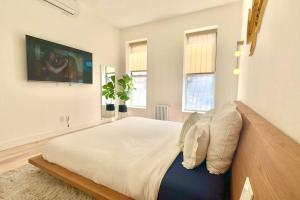 布鲁克林Ultra-Luxury stylish suite in historic Brooklyn的卧室配有一张大床,墙上配有电视