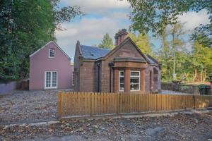 邓布兰Historical Holmehill Lodge的粉红色房子和围栏