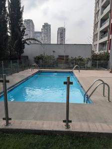 圣地亚哥Habitación amplia en Santiago c3ntro的一座大型游泳池,上面有十字架