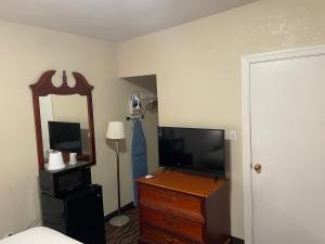 陶森快捷酒店的一间卧室配有电视和带镜子的梳妆台