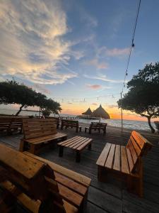 Tintipan IslandTintipan Hotel的海滩上的一组野餐桌,日落