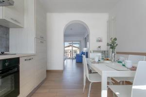 阿布鲁齐的罗塞托Grazioso appartamento seconda fila sul mare - wifi的白色的厨房配有白色的桌子和椅子