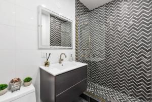 纽约Top Notch 2BR Suite Minutes to Central Park的一间带水槽和 ⁇ 形墙的浴室