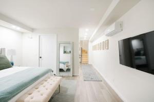 纽约Luxury 2BR Duplex 5min to Central Park的一间白色卧室,配有一张大床和一台电视