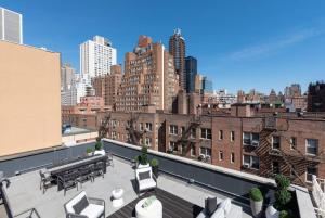 纽约3BR Penthouse with Massive Private Rooftop的大楼内带桌椅的屋顶露台