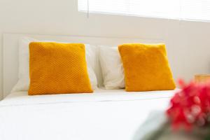 威廉斯塔德Studio Apartment Volterra Curacao的白色沙发上两个黄色枕头