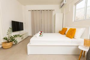 威廉斯塔德Studio Apartment Volterra Curacao的白色卧室配有白色的床和电视