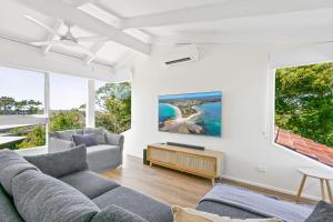 文森提亚Sunrise Point Beach House by Experience Jervis Bay的客厅设有两张沙发和一个大窗户
