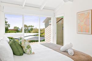 文森提亚Sunrise Point Beach House by Experience Jervis Bay的卧室配有带枕头的大型白色床
