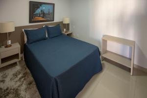 戈亚尼亚Flat inteiro Ônix Bueno的一间卧室配有蓝色的床和蓝色的床单