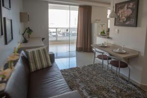 戈亚尼亚Flat inteiro Ônix Bueno的带沙发和桌子的客厅以及厨房。
